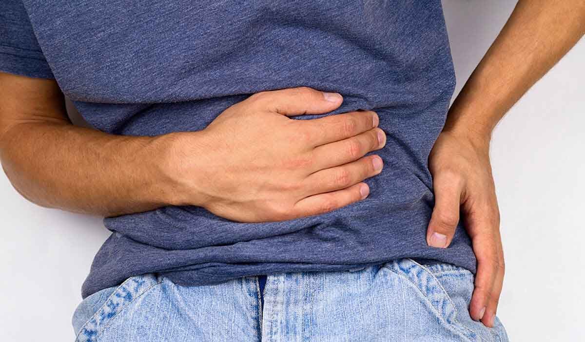 man holds his stomach because of pain from gallbladder disease