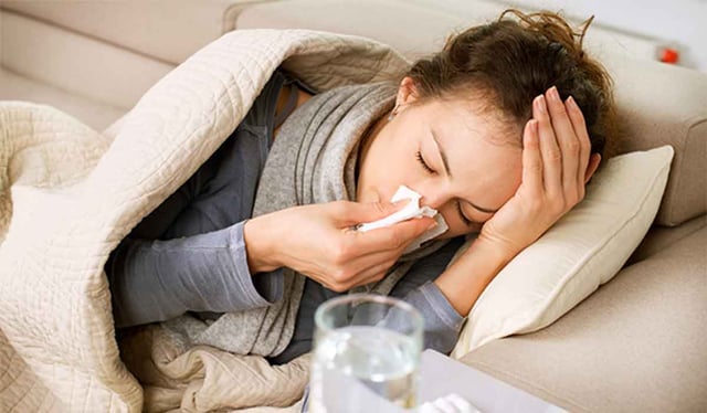 Woman sick with a head cold
