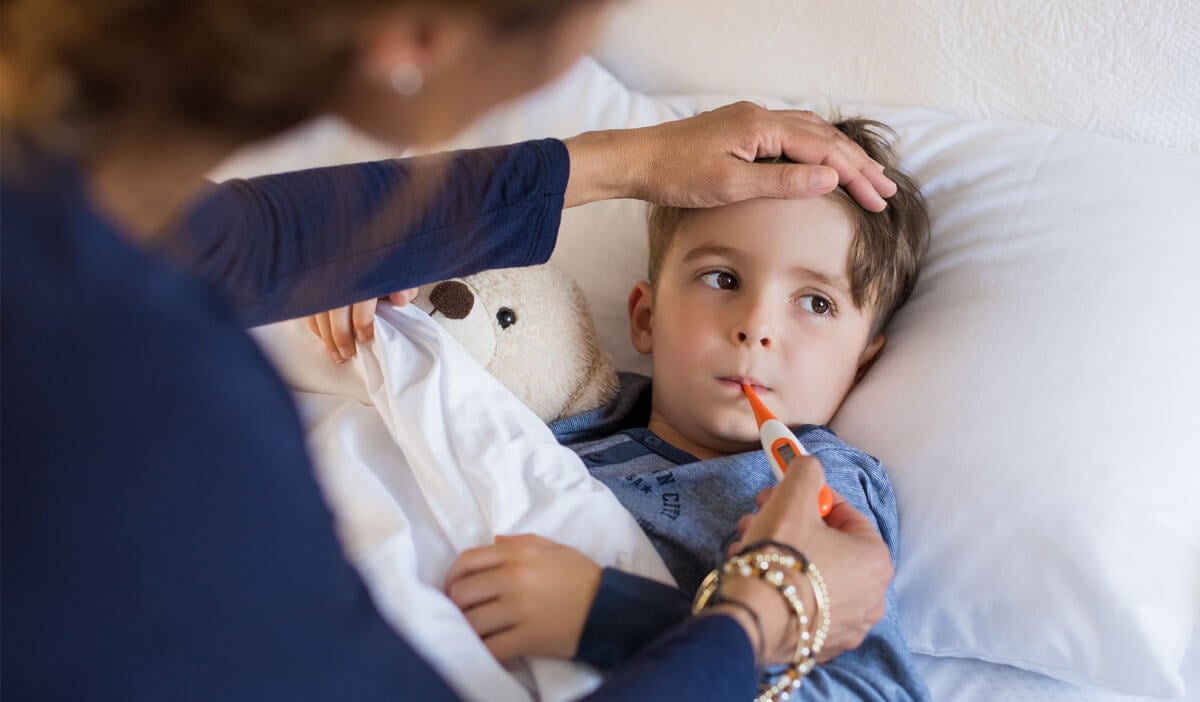 Mom uses a thermometer to measure her child's fever