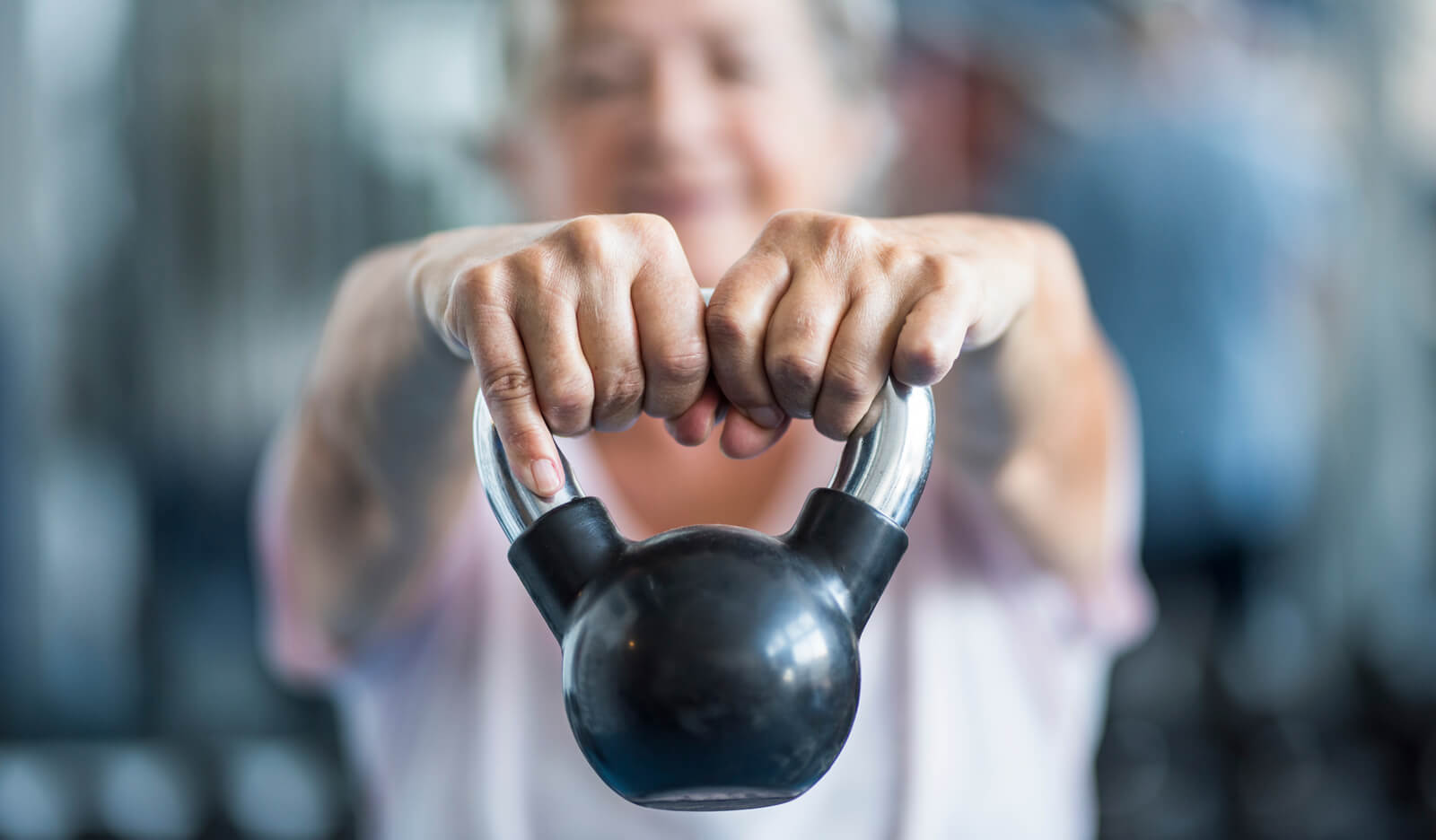Woman does strength training with a kettle ball